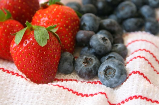Strawberries and Blueberries on a white cloth with red stripes. Used a shallow DOF