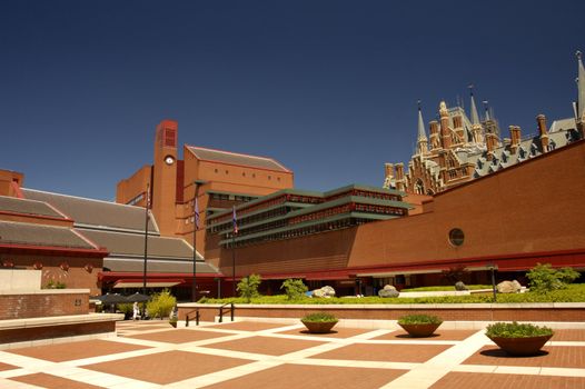 View of the courtyard of the british Library, London, with the gothic towers of St Pancras Station peeping over the top at the right. Space for text in the clear blue
sky.