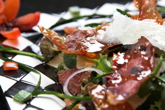 Delicious healthy green salad with crispy parmaham, tomatoes, courgette and parmesan cheese