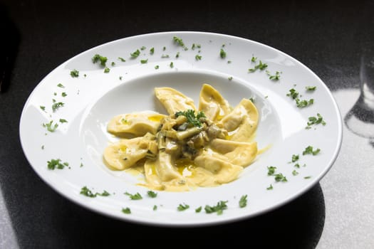 Beautiful Italian pasta dish with courgette, filled pasta, mushrooms made in a sauce of cream and some oil and herbs topped off with a little bit of parsley