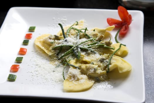 Delicious Italian pasta dish decorated with slices of courgette and sprinkled with parmesan cheese