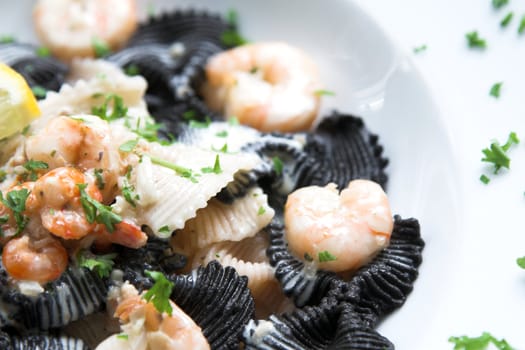 Pasta dish with black pasta and tigerprawns