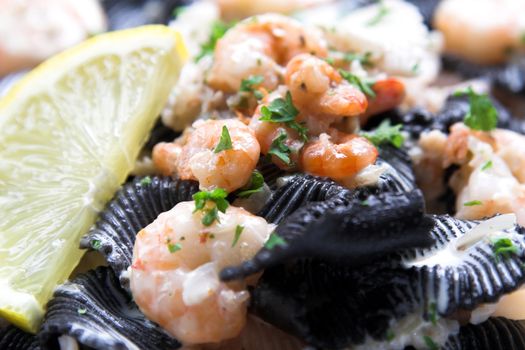 Black pasta filled with tigerprawns and decorated with a lemon