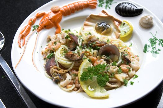 Delicious dish with spaghetti, mussels and squid served on a colorfull seafood plate