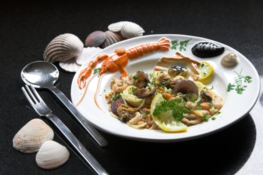 Delicious pasta dish with spaghetti, mussels and shrimp on a colourful plate