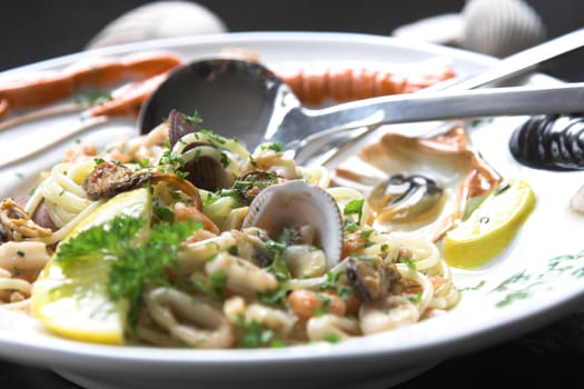 Delicious seafood dish served with shells, shrimps, squid and a slice of lemon on a colorfull plate