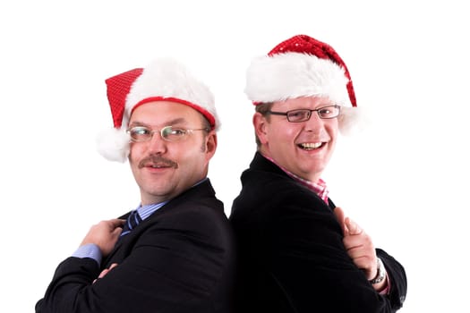 Two businessman standing back to back with christmas hats on