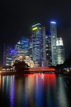 Colorful city night with skyscrapers near river in Singapore, Asia.