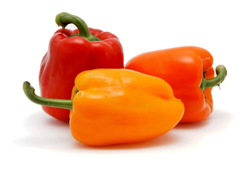 Three sweet bell peppers in red, orange and yellow colors on white background