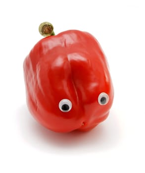 Sweet red bell pepper with eyes on white background