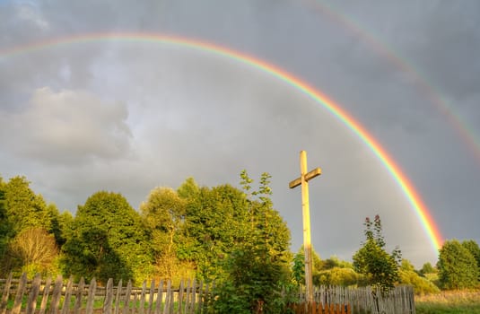 cross and rainbow after summer rain