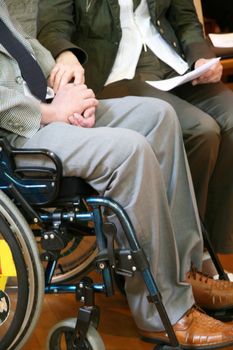 Man in wheelchair with a women holding his hand