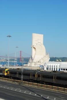 photo of a cityscape in Lisbon regarding the monumet of discoveries and April 25th bridge