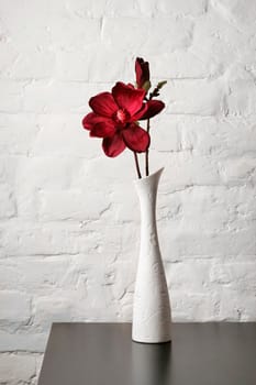 Flower in the white vase on the table