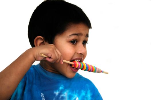 An handsome Indian kid savoring his colorful candy