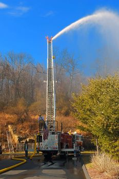 Couple of fire fighters spraying water to stop the forest fire