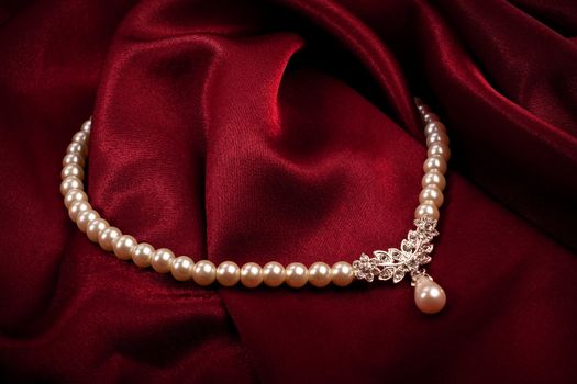 Pearl necklace on dark red background