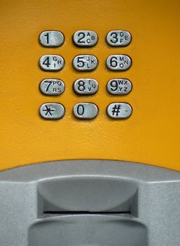 Yellow public phone keypad with card reader