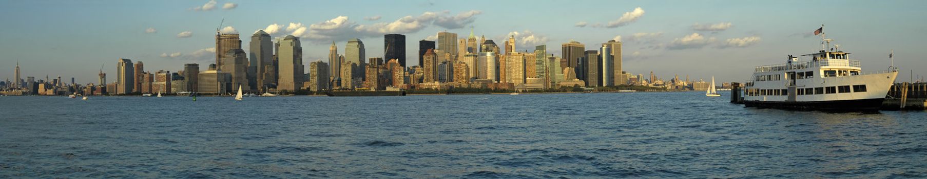 Manhattan panorama photo, white passenger boat in foreground, photograph taken from New Jersey