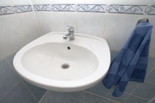 white basin detail photo, blue towel, tiled walls