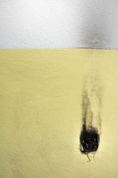 burned electric light switch on  yellow wall