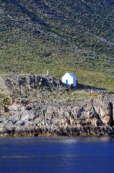 Travel photography: Isolated white Greek chapel by the sea