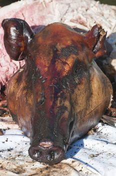 Head of a pig roasted on a grill