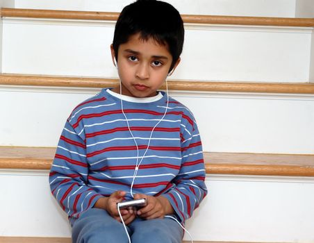 An handsome indian kid listening to music
