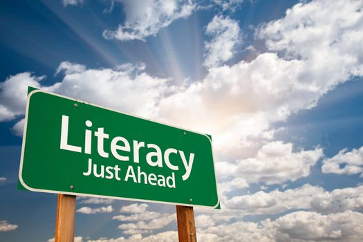 Literacy Green Road Sign with Dramatic Clouds, Sun Rays and Sky.