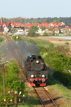Steam retro train passing the village