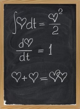 calculus formulas with a heart as argument sketched with white chalk on blackboard with eraser smudges