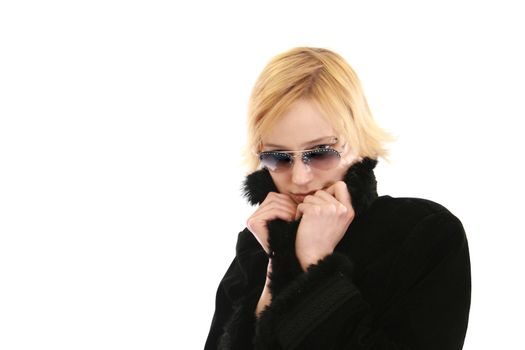 Blonde woman in a long black coat and sunglasses