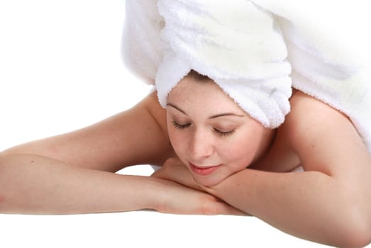 Pretty girl laying down, hair wrapped in a towel. Spa theme.