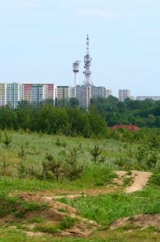 Bike trail with block of flats and radio towers in background