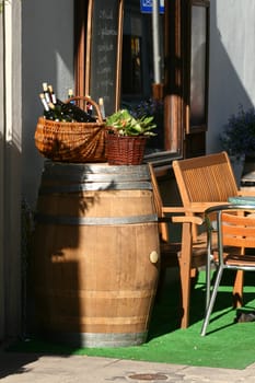 Small wine restaurant in the street an old city. Baskets with bottles of wine and salads