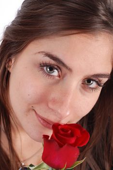 Young woman smelling a red flower