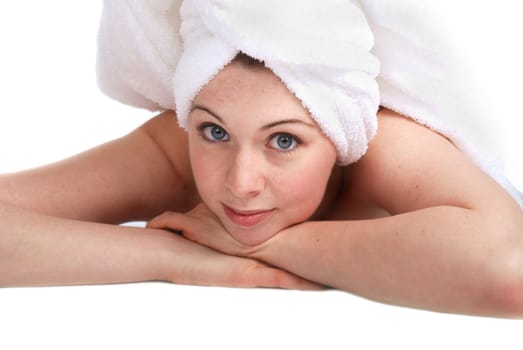 Pretty girl laying down, hair wrapped in a towel. Spa theme.