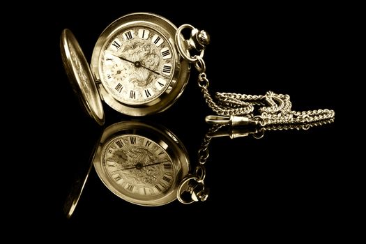 old pocket watch on black background with reflection