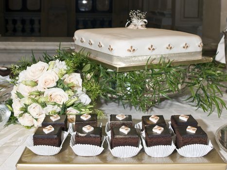 Wedding chocolate cakes and main wedding cake with bridal bouquet