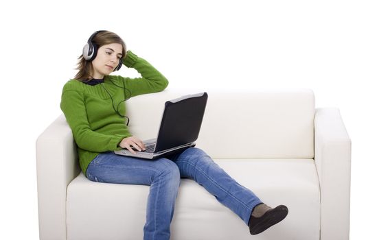 Young woman with headphones and a laptop, seated on a sofa isolated on white