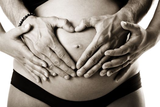 Pregnant women wrap her arms around the belly in the form of the heart. Isolated on white. 