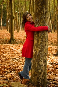 Portrait of a beautiful young woman relaxing close to a tree