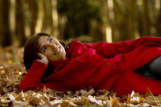 Portrait of a beautiful young woman relaxing in a Autumn background