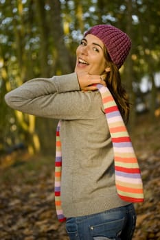 Autumn portrait of a beautiful happy young woman with a colored scarf