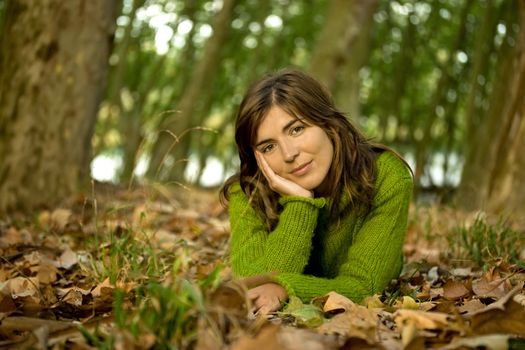 Portrait of a beautiful young woman relaxing in a Autumn background