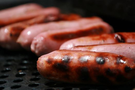 pink pork sausages on a bbq