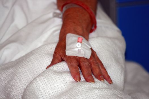 focus on an senior citizens hand with the connections in place for a drip