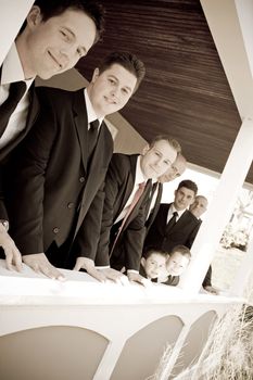 A groom and his groomsmen posing together in a row.