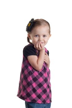 An adorable young toddler girl standing with her hand under her chin.