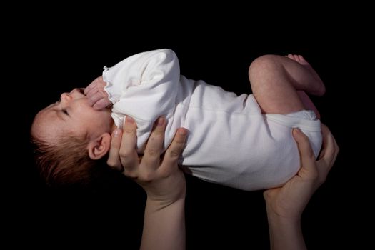 Baby being held in the air.